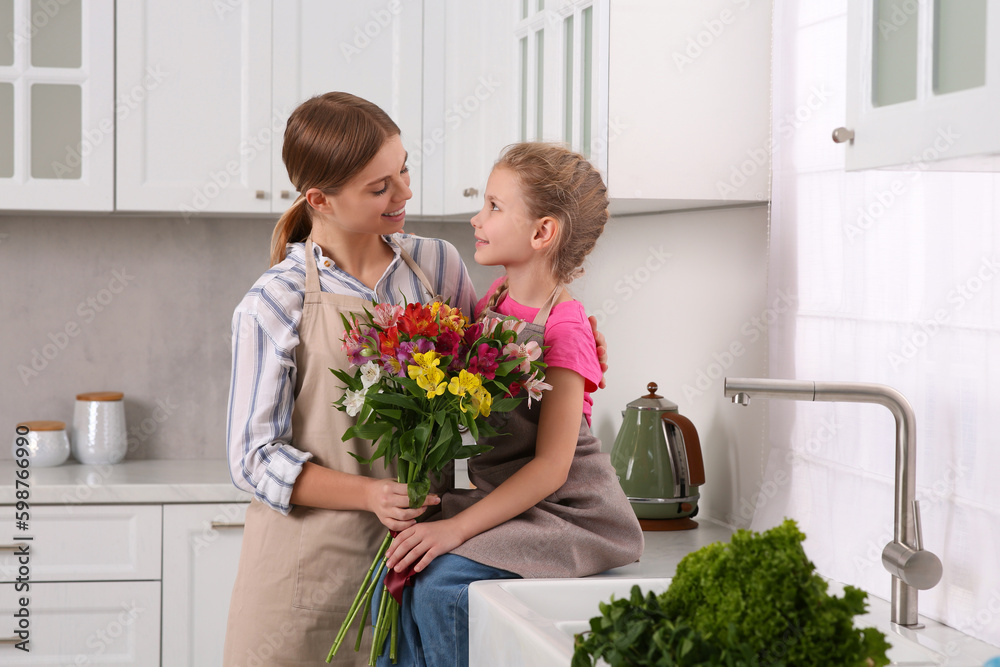 Canvas Prints Little daughter congratulating mom with bouquet of flowers in kitchen. Happy Mother's Day