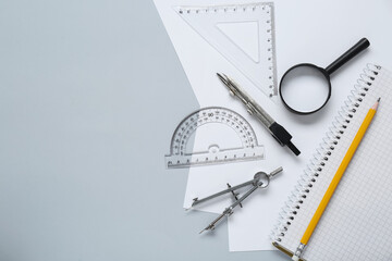 Different rulers and compasses on light grey background, flat lay. Space for text