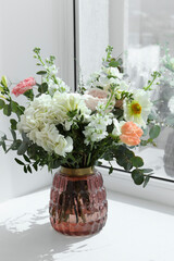 Obraz na płótnie Canvas Bouquet of beautiful flowers on windowsill indoors