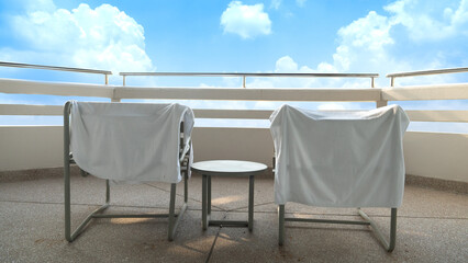 Rat cloth covering the chair to sit and enjoy the view. On the fence of the building behind the room made of cement and round steel. Under blu sky and white clouds.