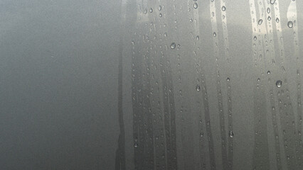 Abstract of Running path of dew drops. On surface gray color body of car.