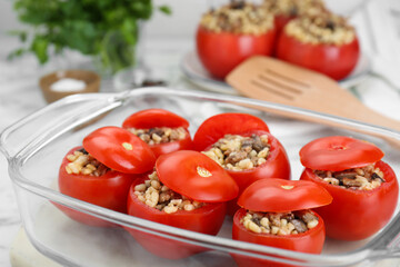 Delicious stuffed tomatoes with minced beef, bulgur and mushrooms in glass baking dish, closeup