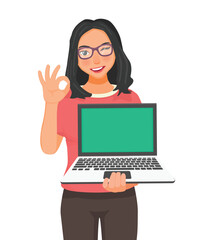 Young beautiful woman with glasses holding laptop with blank screen for copy space showing okay gesture