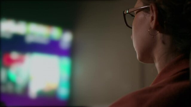 Close Up and Pan of Caucasian Woman Browsing Television Guide. Shot with ARRI Alexa in ARRIRAW and exported QuickTime Apple ProRes 422 HQ.
