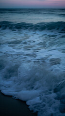 Closeup of the waves on the beach by the coast

