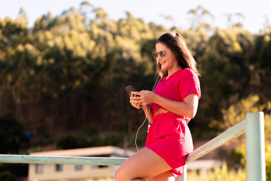 Young woman happy using her smartphone to access social networks or mobile apps through 5G technology.
