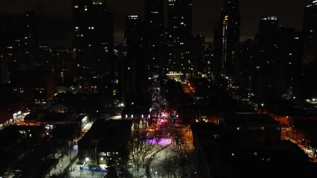 Police block off side street alley in city at night time, flash red lights, aerial view