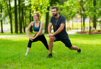 Image of young smiling couple, woman training with man or bearded coach trainer, doing squat fit...