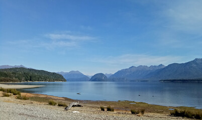 A man standing in front of breathtaking Lake Te Anau landscape in New Zealand.