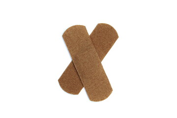  On a white isolated background there is an adhesive plaster in the form of a cross.	