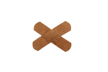 On a white isolated background there is an adhesive plaster in the form of a cross.