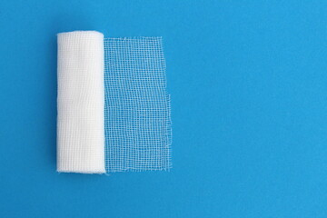 A white medical bandage lies on a blue background.