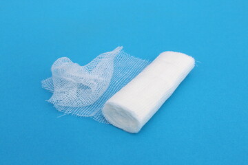 A white medical bandage lies on a blue background.