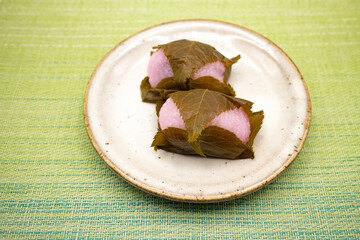 陶器皿にのった桜餅・道明寺2個、和菓子
Japanese sweets "Sakura mochi Doumyouji" on a ceramic plate.