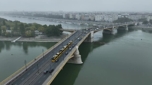 Aerial view of Budapest Margaret Bridge or Margit hid over River Danube, embankment. Public transport in the city. Yellow tram passing through the bridge