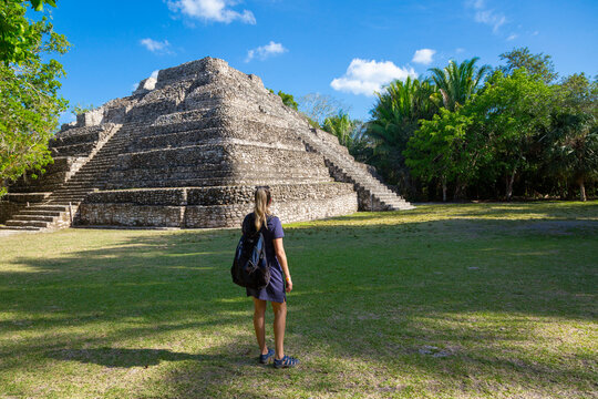 View from behind of a woman visiting Mayan Ruins in Central American. Learning about the ancient civilization of the Mayan while on a Cruise vacation in Belize.