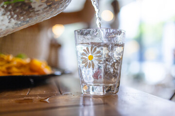 Pour water into glass on the table