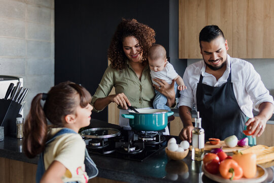 latin family cooking together with children daughter and son in kitchen at home in Mexico Latin America, hispanic people