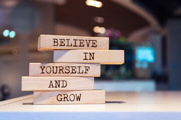 Wooden blocks with words 'Believe in yourself and grow'.