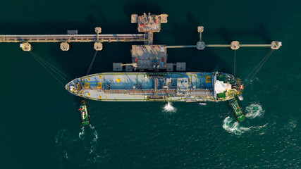 crude oil floating station in sea, bridge pipeline load unloading crude oil from oil ship transport, industry business transportation by container ship open sea, aerial view from drone