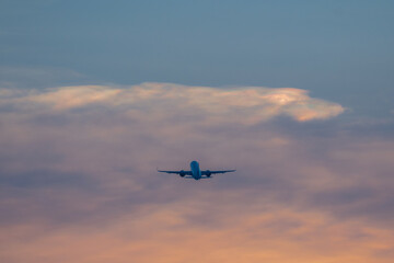 Fototapeta na wymiar Airplane flying at sunset, Airliner passing at sunset, vanilla sky.
