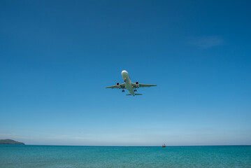 Fototapeta na wymiar landing of a passenger airliner on blue sea