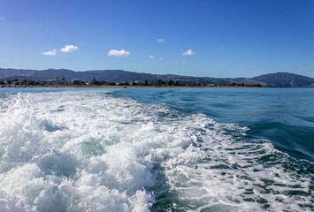 Frothy white waves in the wake of a boat leaving the mainland from Paraparaumu heading for Kapiti Island.