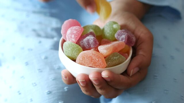 women hand pick colorful candy sweet jelly in a bowl on table  Generative AI