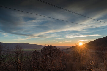 A scenic sunset over a wooded area.
