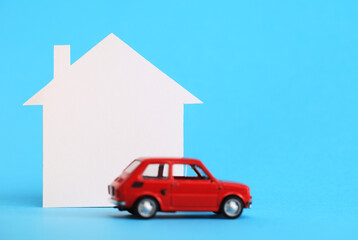Mini house, red miniature car on blue background