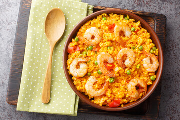 Yellow rice with shrimps arroz con camarones close-up in a bowl on the table. horizontal top view from above