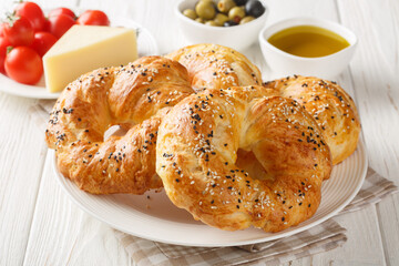 Turkish pastry close up of tasty fresh acma with cheese, black olive, tomato and cheese on the table. Horizontal