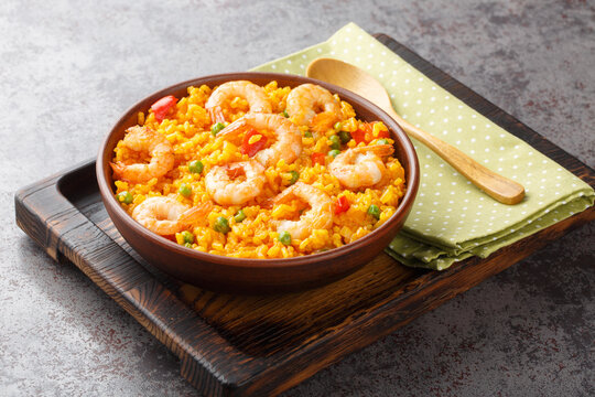 Spicy yellow rice with shrimps and vegetables close-up in a bowl on the table. horizontal