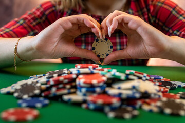 Fototapeta premium woman's hand takes poker chips from a pile at a round poker table.
