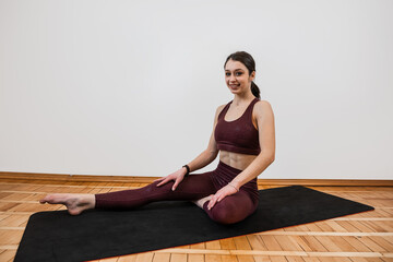 Fototapeta na wymiar Full length - young fit woman wear sport cloth doing yoga exercise on mat