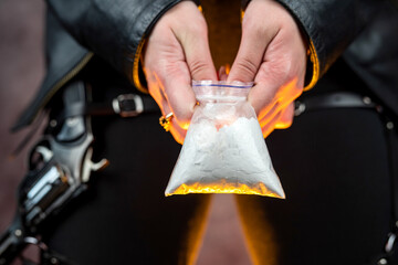 female dealer holds packet with heroin for sale