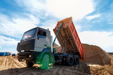 Delivery of sand to the construction site by truck with raised body