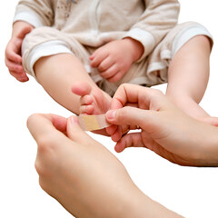Mother woman sticks a medical band-aid on the toddler baby leg, isolated on a white background. Mom s hand with sticky wound protection tape and child s foot