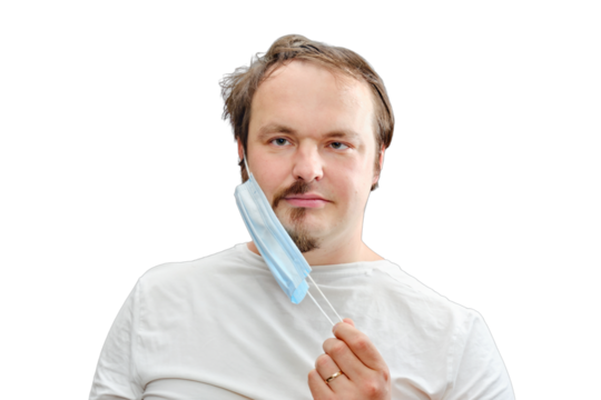 The man removes the medical mask under which the half-shaved beard and disheveled hair, isolated on a white background. The concept of closed salons and barbershop during the isolation of coronavirus