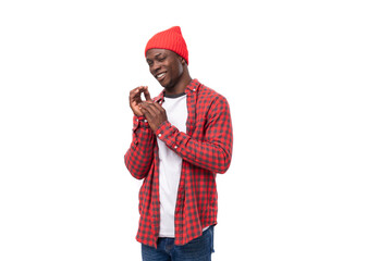 handsome embarrassed dark-skinned man in a casual plaid shirt of model appearance on a white background with copy space