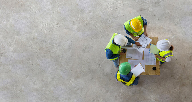 Top view of engineer, architect, contractor and foreman meeting at the construction building site with floor plan for real estate development project industry and housing timeline usage