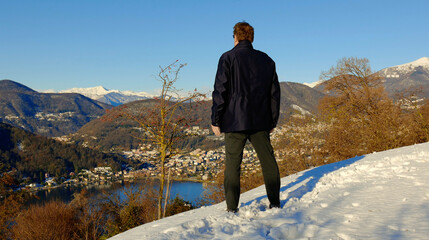 Man Enjoy Mountain View from Switzerland to Italy in a Sunny Winter Day in Collina di Oro, Lugano,...