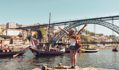Happy woman tourist visiting Porto, Portugal- cityscape of Porto,famous brige,Douro river and gondola boat