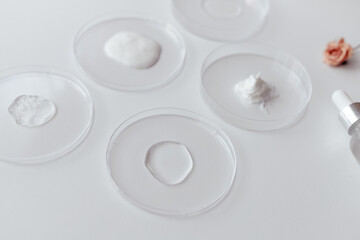 Cosmetics Samples in Laboratory Glassware on white background, consistency test of gel and cream