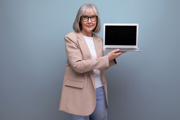 confident adult woman in a jacket with a laptop on a bright background with copy space