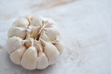 Allium sativum. whole piece of garlic on a white wooden table. Garlic is a cooking spice