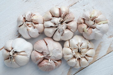 garlic on a white wooden table. Garlic is used as a spice in cooking in Europe, Asia, America, Africa and Australia. Allium sativum