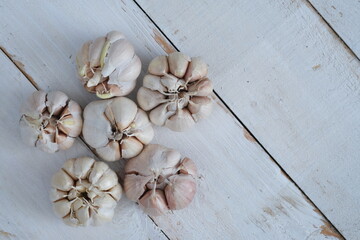 garlic on a white wooden table. Garlic is used as a spice in cooking in Europe, Asia, America, Africa and Australia. Allium sativum