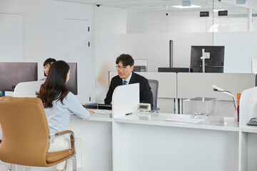 직원에게 은행 상품을 안내받고 있는 고객