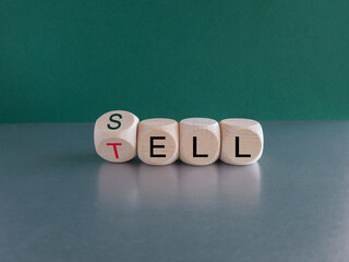 Sell or tell symbol. Turned wooden cubes and changed the concept word Tell to Sell. Beautiful gray table green background, copy space. Business and storytelling storyselling sell or tell concept.